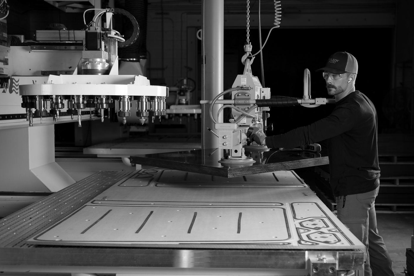 A craftsperson working at a large CNC machine in the Wilson Audio factory