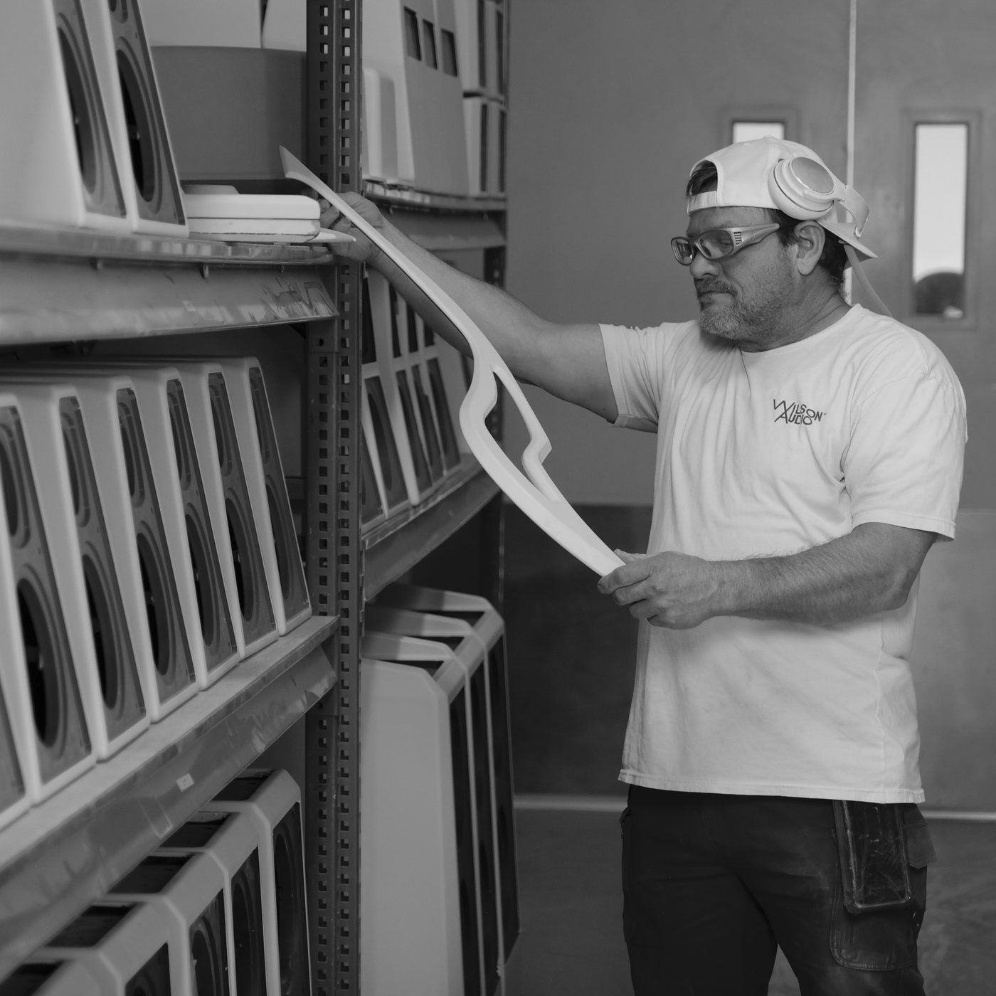 A craftsperson inspecting a gantry rail against the light