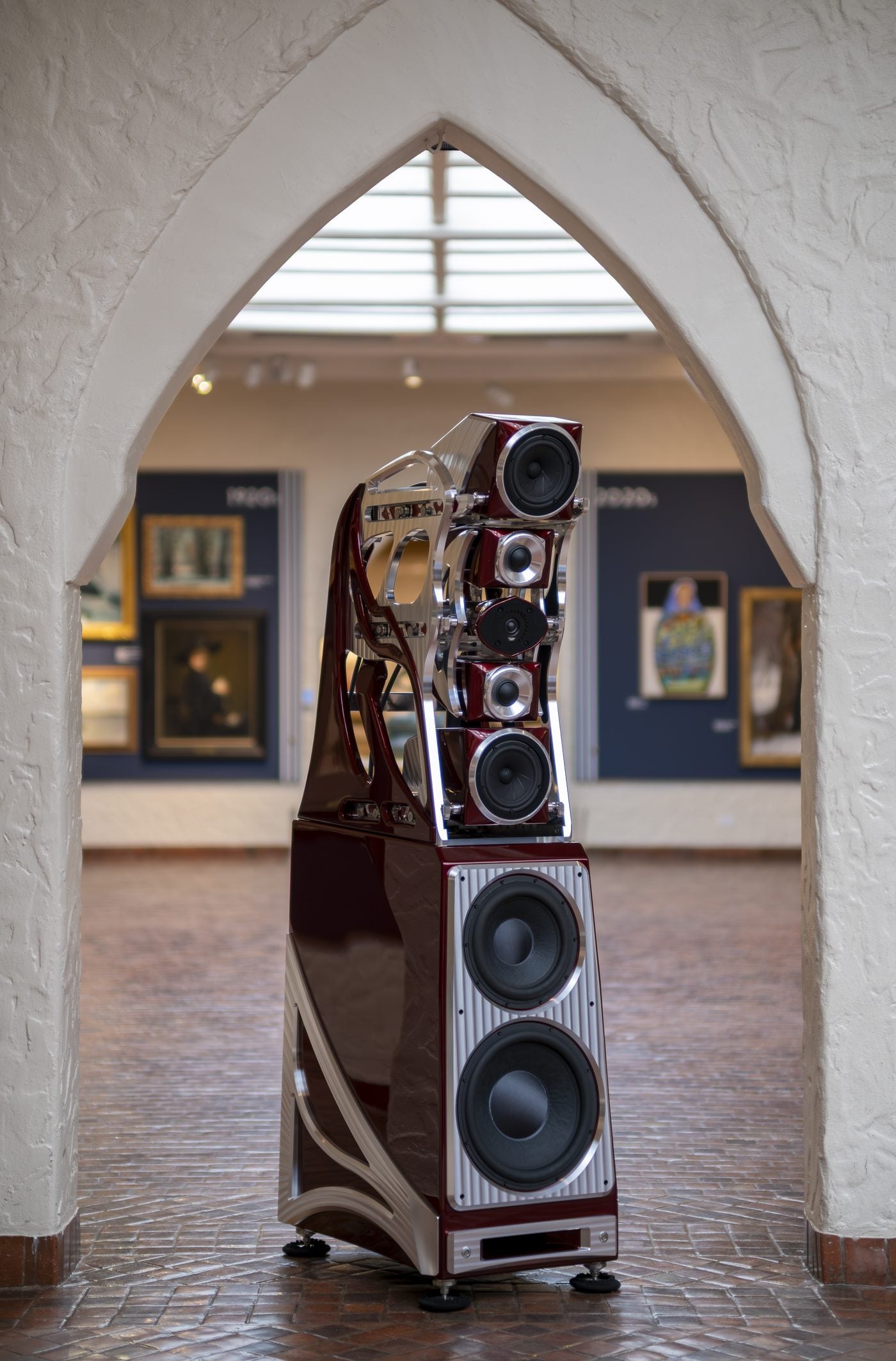 An Autobiography loudspeaker in Crowned Rose, framed by a stone archway in a gallery at the Springville Museum of Art